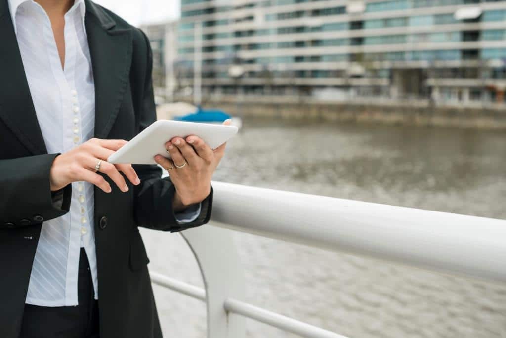 mid section young woman standing near harbor using mobile phone